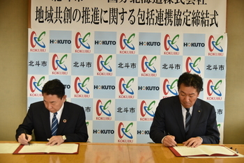署名をする池田市長と諏訪代表取締役社長