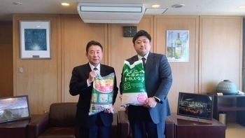 長尾取締役からふっくりんこの寄贈を受ける池田市長