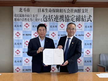 協定書を持つ池田市長と小林函館支社長