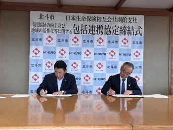 協定書に署名を行う池田市長と小林函館支社長
