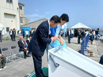 ヒラメの稚魚放流を行う池田市長